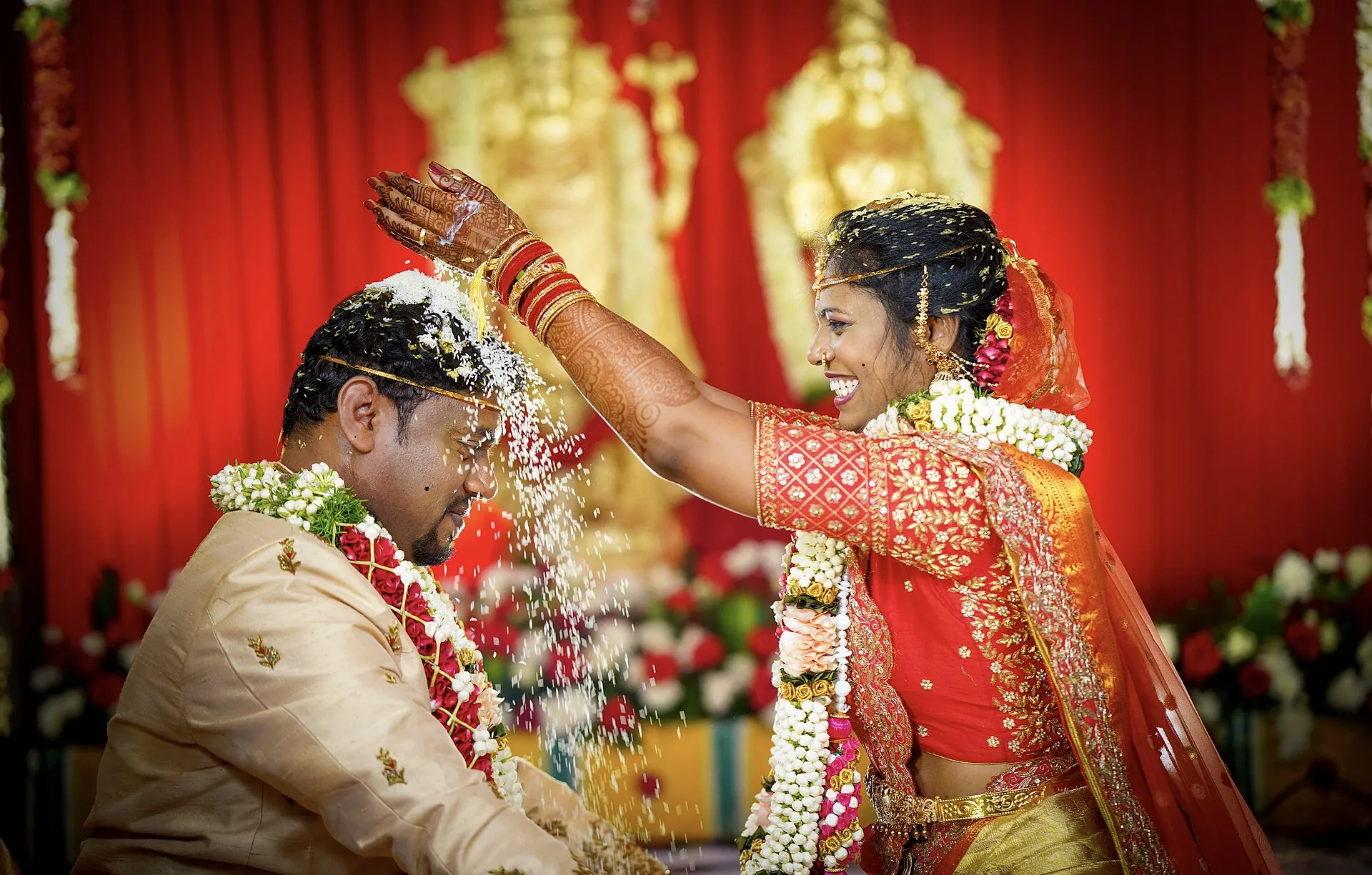 Bride showering blessings on the groom during the ceremony